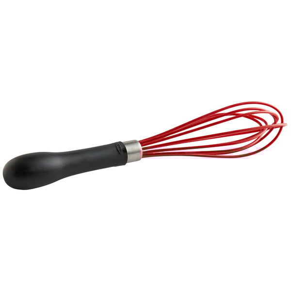 An OXO Good Grips red and black silicone whisk with a black handle.