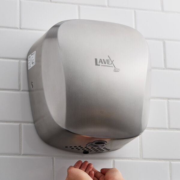 Hands drying underneath electric hand dryer
