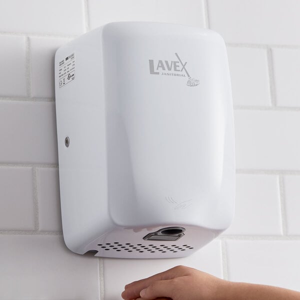 White hand dryer surface mounted on a white tile wall