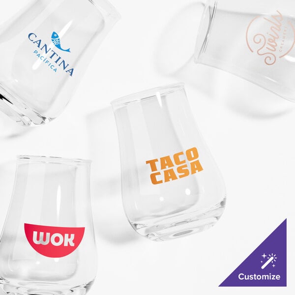 A close-up of a clear Acopa tulip glass with a logo on it.