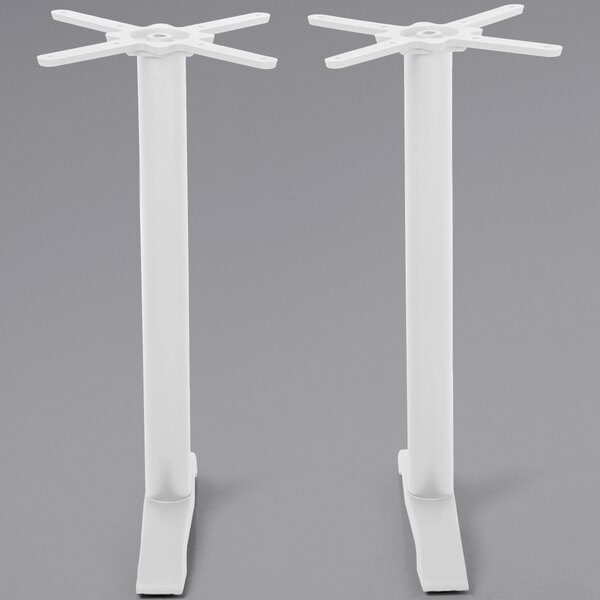 A pair of white BFM Seating Bali steel end table bases with circular designs on the legs.