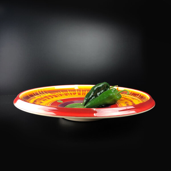 A Elite Global Solutions round melamine platter with a green pepper on it.