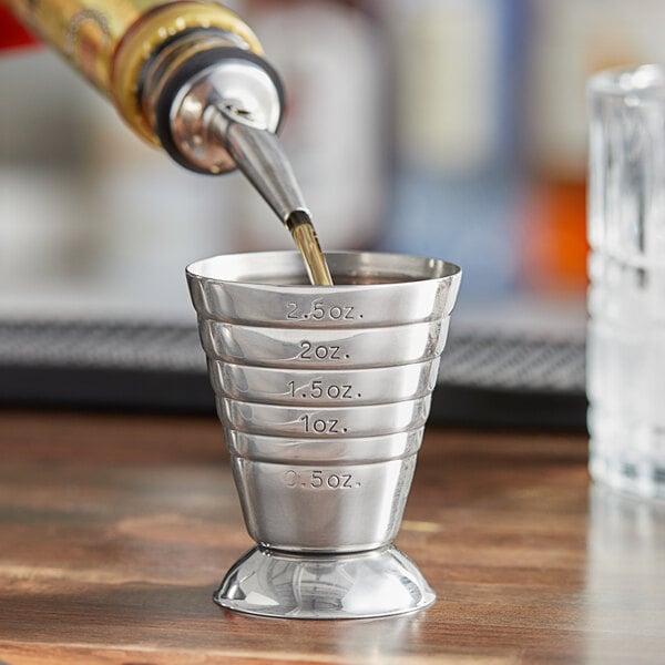 A Barfly stainless steel measuring jigger on a table.