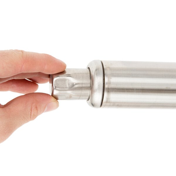 A hand holding a Noble Warewashing undercounter dish machine stand.