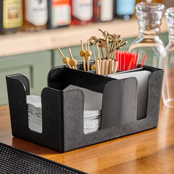 A black Choice bar caddy on a counter with napkins and toothpicks inside.