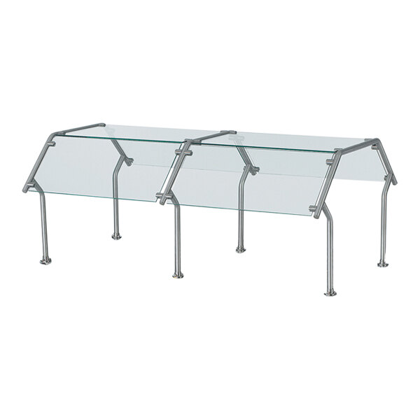 A Vollrath double-sided buffet sneeze guard with metal legs over a table.