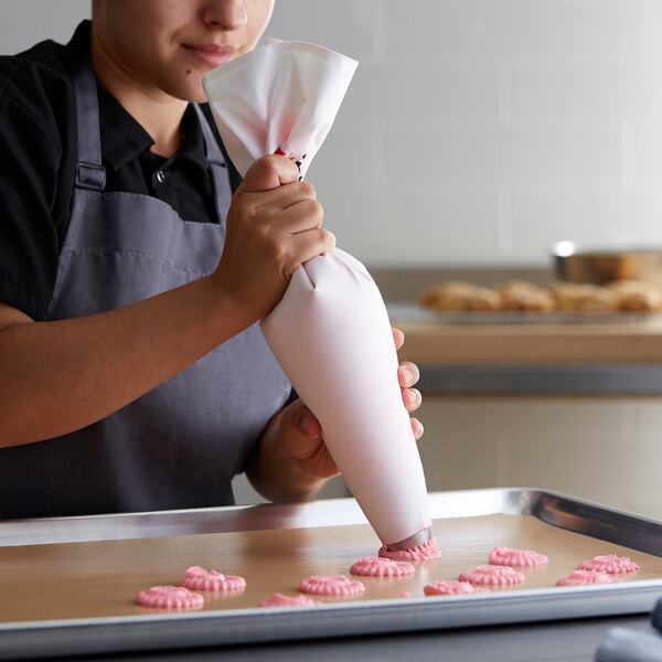 Baker using a plastic-coated canvas pastry bag to pipe dough