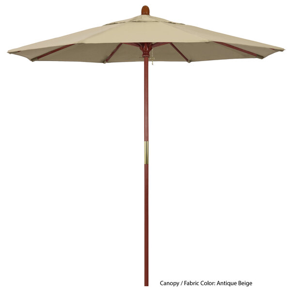 A close-up of a California Umbrella Grove round outdoor umbrella with a Sunbrella tan canopy and hardwood pole.