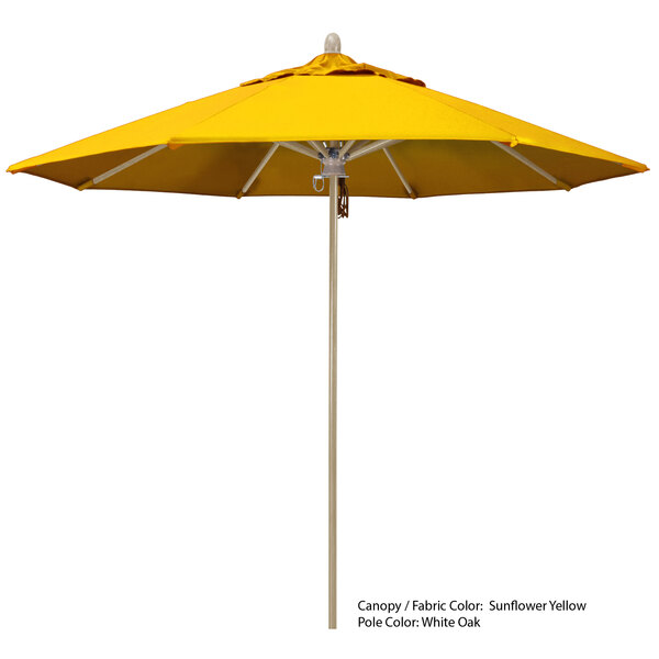 A yellow California Umbrella with a wooden pole on a white background.