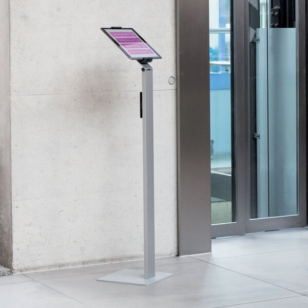 A Durable silver metal floor stand with a tablet on it.