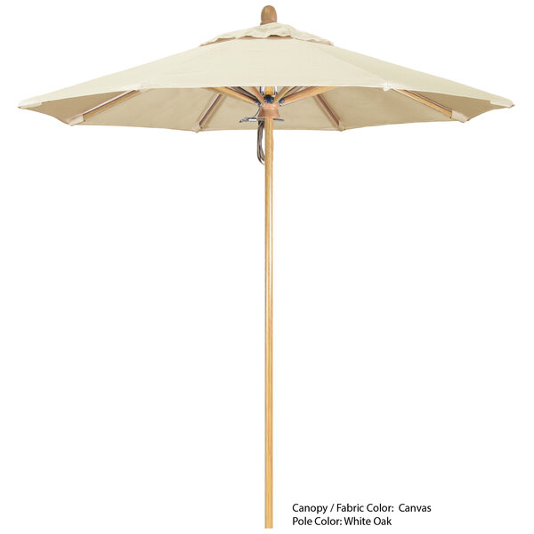 A California Umbrella with a tan Sunbrella canopy and a wooden pole.