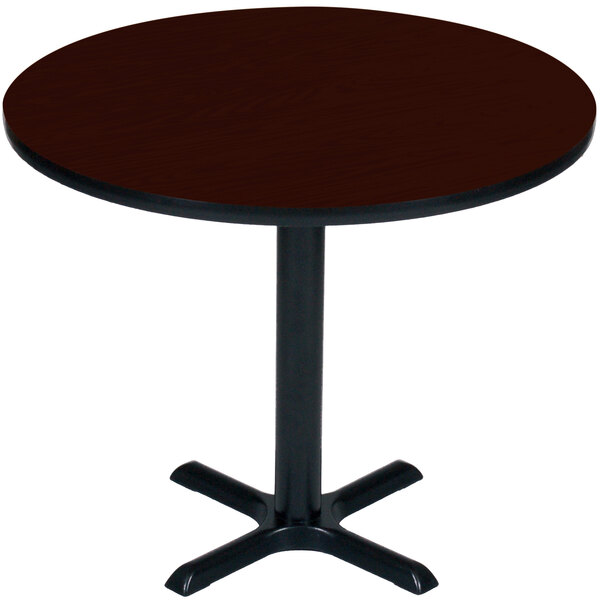 A Correll round mahogany table with a black base.