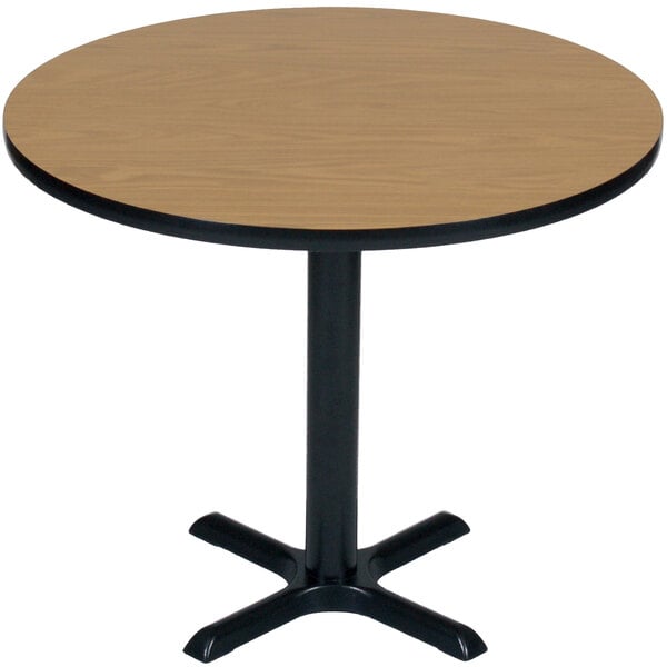 A Correll round table with medium oak and black base.
