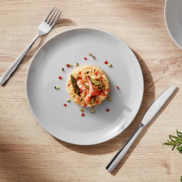 A Arcoroc granite gray opal glass coupe plate with rice, shrimp, and asparagus on it with a fork.