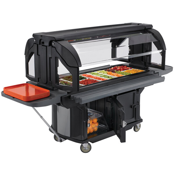 A black Cambro food cart with a tray of vegetables on a table at a food buffet.