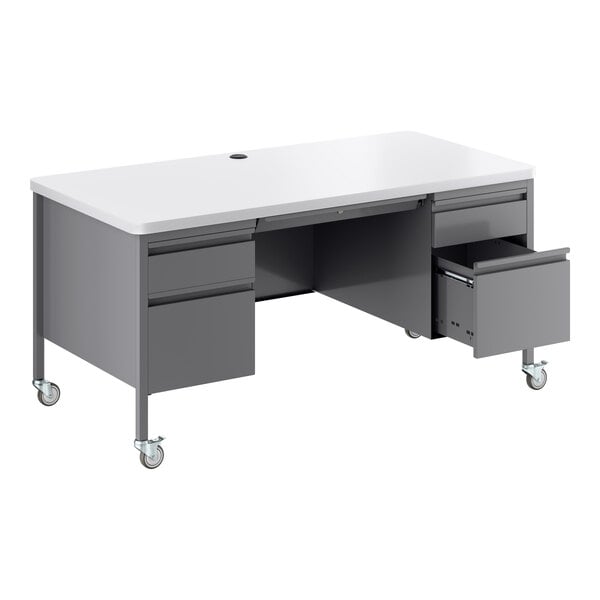 A mobile double pedestal teacher's desk with a white top and platinum-colored base, featuring multiple drawers and caster wheels.