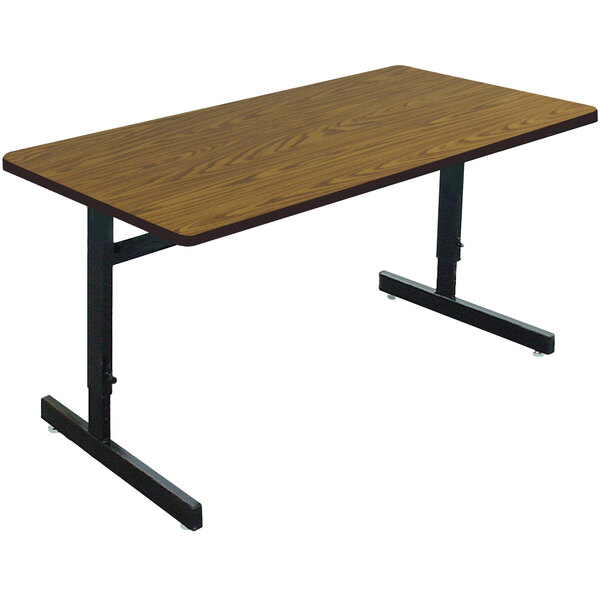 A Correll rectangular computer table with a medium oak top and black base.