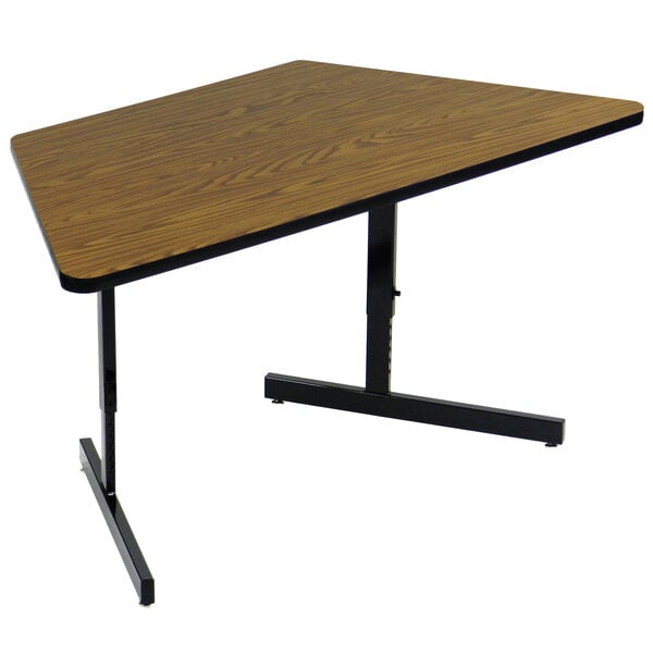 A Correll trapezoid computer table with a medium oak top and black base.