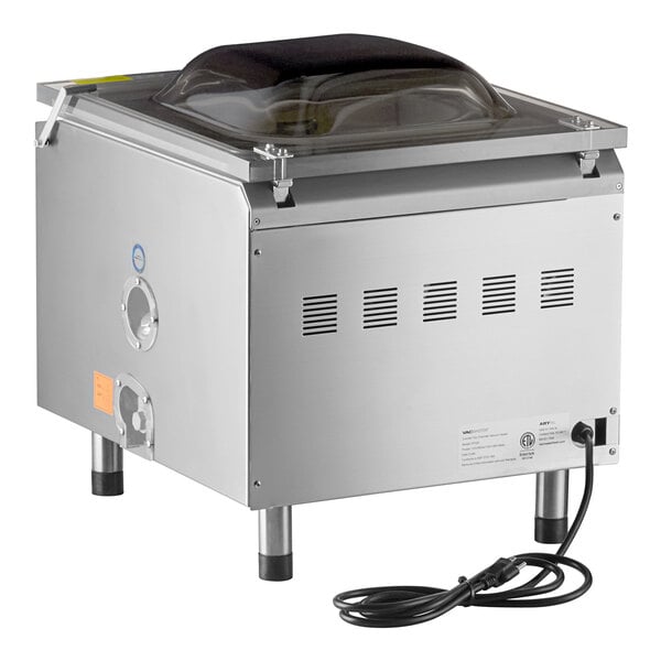 A stainless steel tabletop vacuum packaging machine with a clear domed lid and attached power cord.