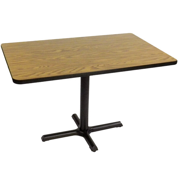 A Correll rectangular table with a medium oak top and a black base.