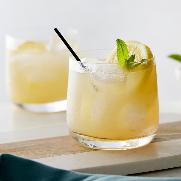 Two Chef & Sommelier rocks glasses filled with lemonade and ice, garnished with lemon slices and mint leaves.