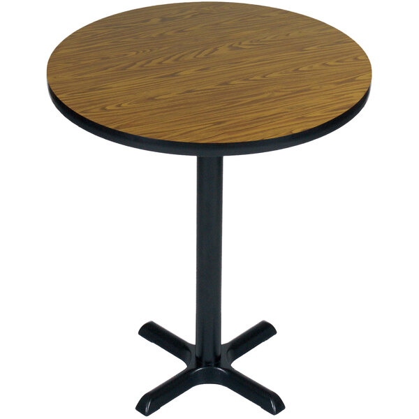 A Correll round wooden bar height table with a black base.