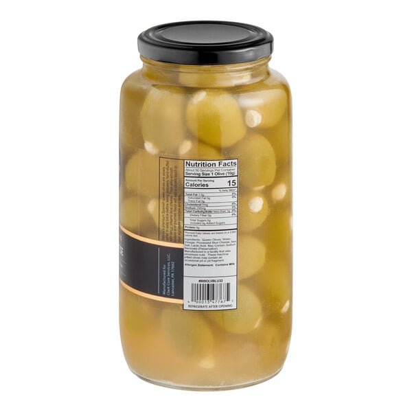 A large glass jar filled with green queen olives stuffed with blue cheese and sealed with a black lid.