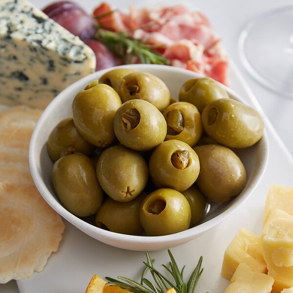 A white plate with a bowl of Belosa Jalapeno Stuffed Queen Olives and cheese.