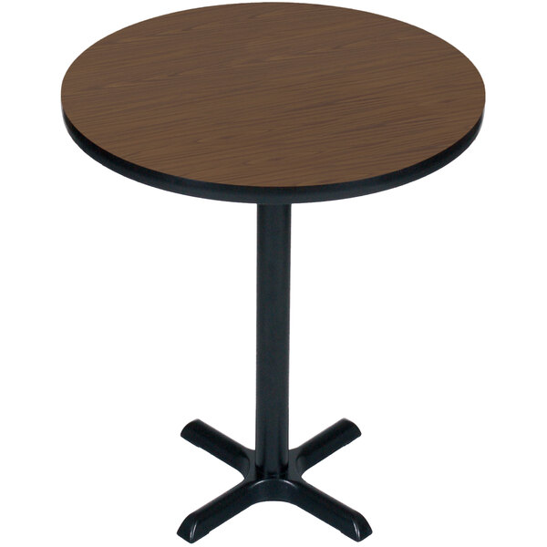 A round brown table with a black base.