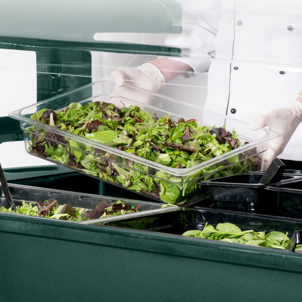 A gloved hand serves salad from a Carlisle Maximizer portable salad bar.