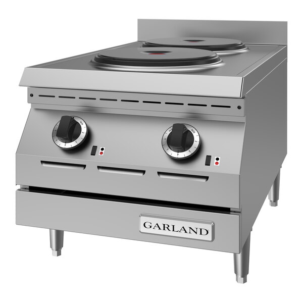 A stainless steel countertop hot plate with two solid electric burners and control knobs.