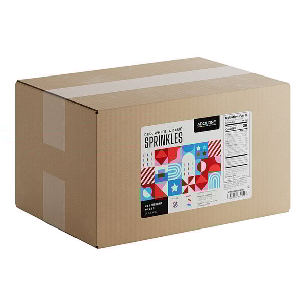 A large cardboard box labeled as containing 10 pounds of Adourne red, white, and blue sprinkles.