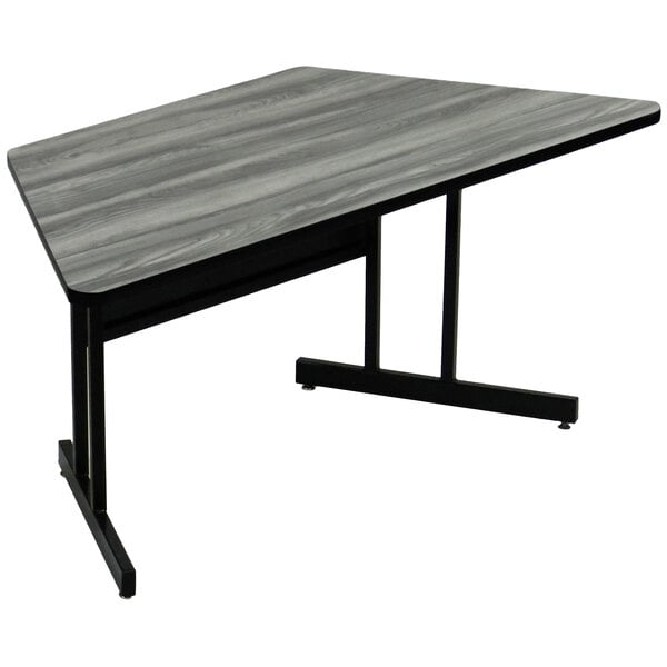 A Correll New England Driftwood trapezoid computer table with a black metal base.