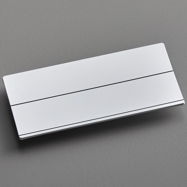 A customizable white rectangular plastic nametag with black lines.