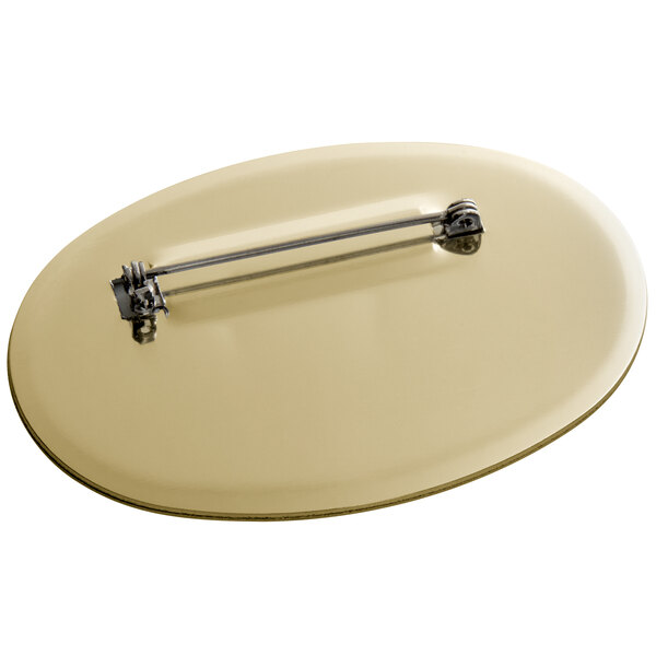 A close-up of a Cawley gold metal oval nametag.