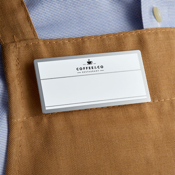 A man wearing a Cawley white rectangle name tag on a brown apron.