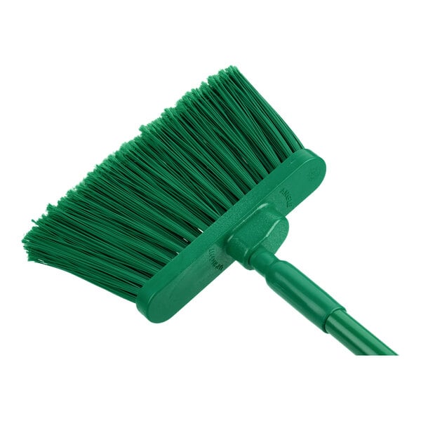 A Carlisle green broom with long handle.