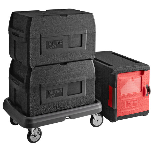 A black Metro Mightylite pan carrier and red BigBoy pan carrier stacked on a dolly.
