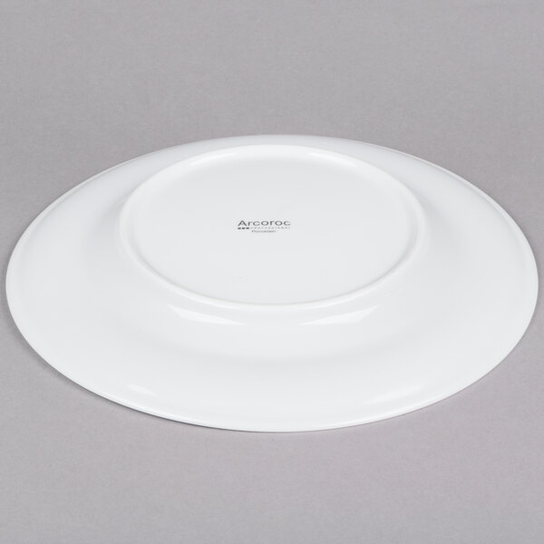 An Arcoroc white porcelain side plate with a small rim.