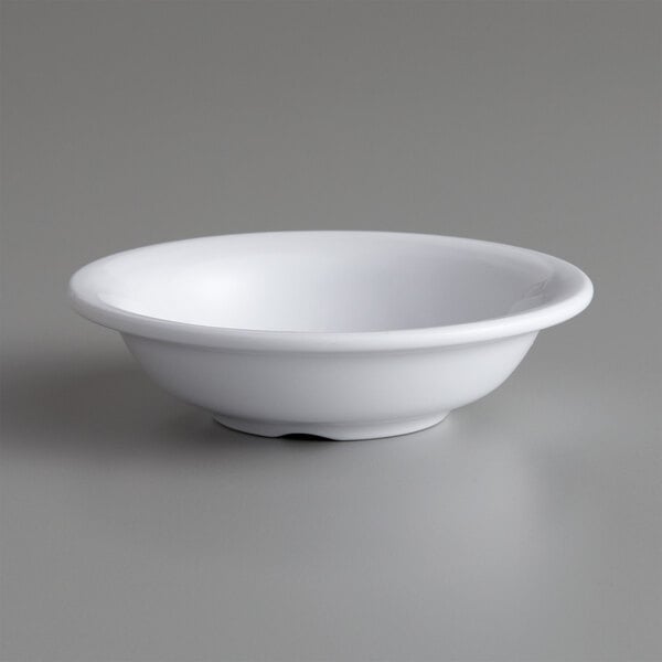 An American Metalcraft white melamine fruit bowl on a gray surface.