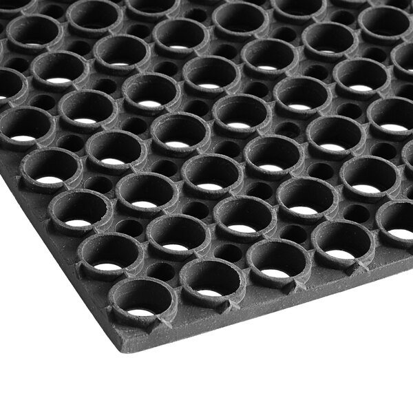 A close up of a Lavex black rubber anti-fatigue floor mat with holes.