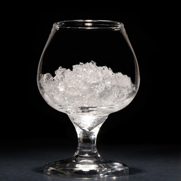 A glass of ice with ice cubes in it.