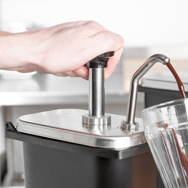 A hand pouring coffee into a metal jar on a counter in a juice bar.