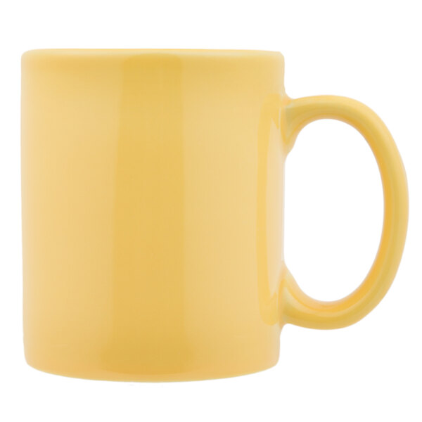 A close-up of the handle of a yellow Tuxton C-Handle mug.