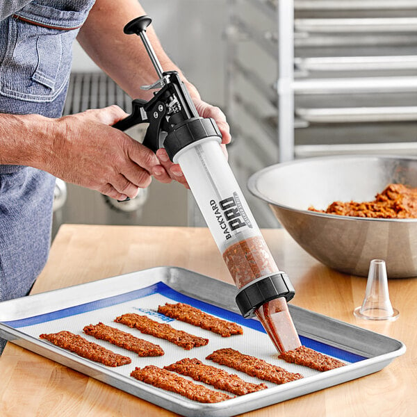 A man using a Backyard Pro jerky shooter to make meat jerky.