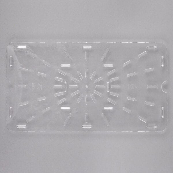 A close-up of a clear plastic Carlisle drain tray with holes in it.