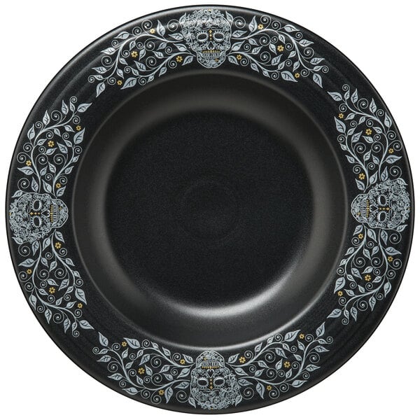 A black Fiesta china bowl with white skulls and leaves on it.