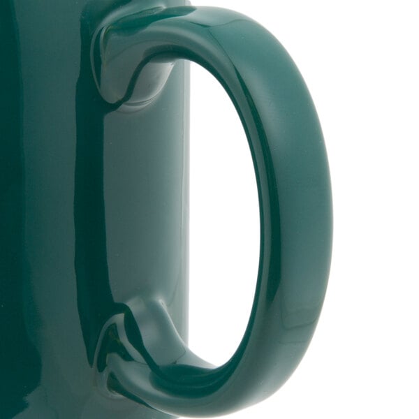 A close-up of a Tuxton Hunter Green china mug with a C-handle.