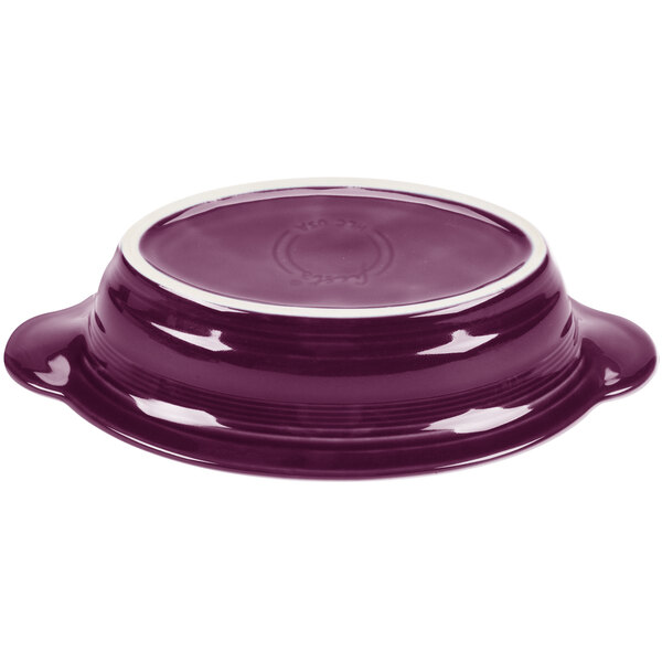 A purple oval china baker with a white rim.