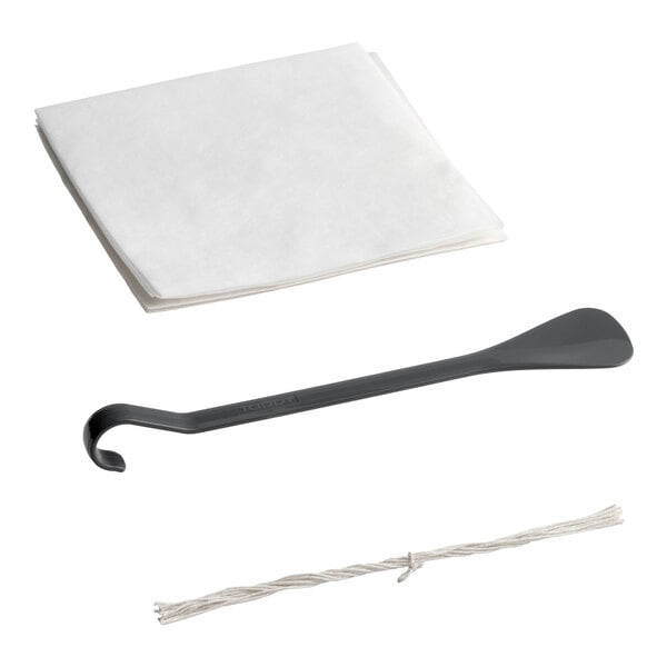A set of cold brew coffee system accessories including paper filters, a plastic stirring tool, and a length of string.